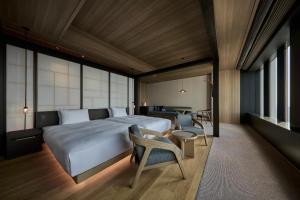 a bedroom with a bed and a table and chairs at The Royal Park Hotel Iconic Nagoya in Nagoya