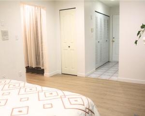 a white room with a bed and a hallway at Lovely 1 bedroom attached full washroom in Surrey