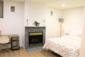 a bedroom with a fireplace and a bed and a desk at Lovely 1 bedroom attached full washroom in Surrey