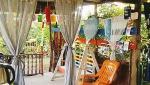 une terrasse couverte avec des chaises et des filets sur une clôture dans l'établissement peaceland farmstay, à Ban Mai (1)