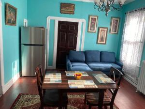 a blue living room with a table and a blue couch at Classic King Suite Apartment in Schenectady