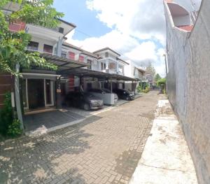 a street in a residential neighborhood with cars parked at Griya Rajawali Homestay Jogja in Kejayan