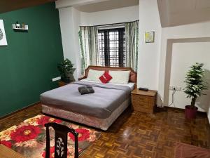 1 dormitorio con cama y pared verde en 100 Oastel coLiving, en Tanah Rata