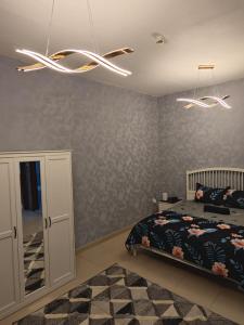 a bedroom with a bed and a chandelier at Ajman preal modren 1 bed room in Ajman 