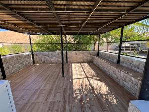 an empty patio with a wooden floor and a roof at Big dune camp in Ḩawīyah