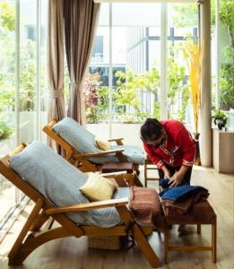曼谷的住宿－薩拜沙通酒店式公寓，一个人在屋子里的床上工作