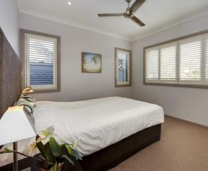 西南岩Front Creek Unit 5 of 16 Paragon Ave South West Rocks - No Sheets or Towels Provided的一间卧室配有一张带吊扇和窗户的床。