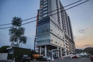 un edificio alto con macchine parcheggiate di fronte di JC Sky Riverfront 'Pebble' w/Fantastic River View a Kota Bharu