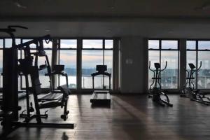 a gym with several exercise bikes in a room with windows at JC Sky Riverfront 'Pebble' w/Fantastic River View in Kota Bharu