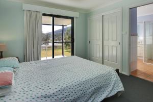 a bedroom with a bed and a large window at Anchor Down at Hat Head - 3 Bream Close in Hat Head