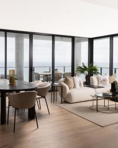 een woonkamer met een witte bank en een tafel bij Sandbar Burleigh - Official in Gold Coast