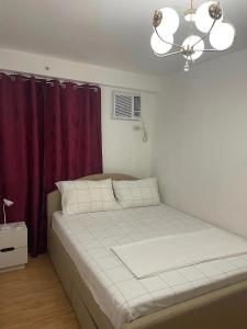 Bett in einem Zimmer mit einem lila Vorhang in der Unterkunft Arezzo Place Davao Condominium in Davao City