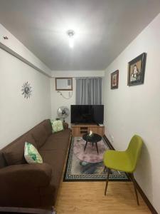 a living room with a couch and a television at Arezzo Place Davao Condominium in Davao City