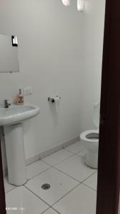 bagno bianco con lavandino e servizi igienici di The Dream House a Quito
