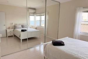 Un pat sau paturi într-o cameră la Sunny Apt on The Esplanade - Aircon