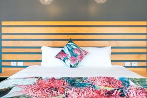 a bed with a wooden headboard and two pillows at Holbrook Motel in Holbrook