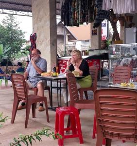 a man and woman sitting at a table in a restaurant at Lak village in Lien Son