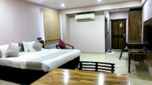 une chambre d'hôtel avec un lit et une table dans l'établissement HOTEL RADHE Anand, à Anand