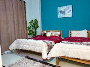 two beds in a room with a blue wall at Joy Homes in Cairo