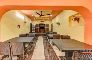 a restaurant with tables and chairs and a ceiling fan at Goroomgo Moon CT Road Puri - 100 Meter From Sea Beach - Best Choice of Travelers in Puri