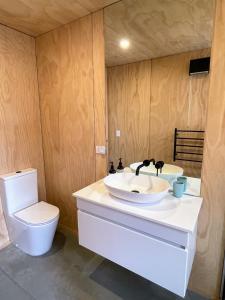 a bathroom with two sinks and a toilet at Mill Creek Cottage in Arrowtown