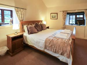 a bedroom with a large bed and a window at How Head Cottage in Ambleside