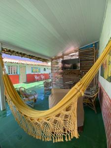 Suites Marisol Buzios في بوزيوس: غرفة مع أرجوحة في منزل