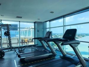 un gimnasio con dos máquinas de correr y un ordenador portátil en Hermosa Suite con vista al rio! Piscina y Parqueo, en Guayaquil