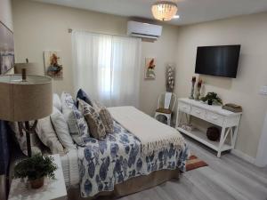 a bedroom with a bed and a flat screen tv at Completely Renovated! Half Duplex 1mile to Beach in Nokomis