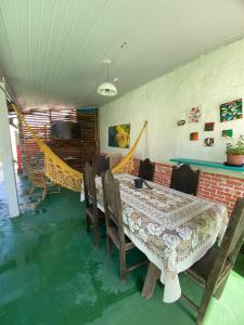 Suites Marisol Buzios في بوزيوس: غرفة طعام مع طاولة وكراسي وأريكة