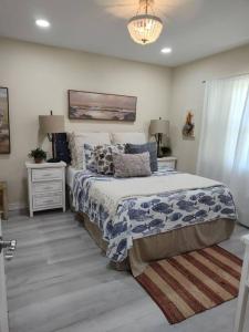 a bedroom with a bed and two night stands and a chandelier at Completely Renovated! Half Duplex 1mile to Beach in Nokomis