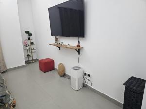 a living room with a tv on a white wall at Luxe Studio Prime area near Airport & Attractions in Dubai