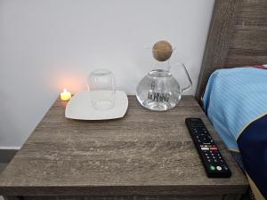 a table with a remote control and a vase on it at Luxe Studio Prime area near Airport & Attractions in Dubai