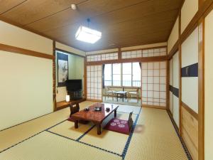 Cette chambre comprend une table et des chaises. dans l'établissement Tomiya Ryokan, à Myōkō