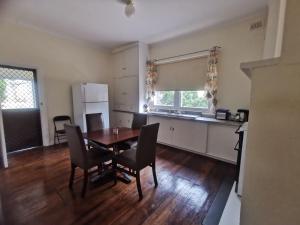 a kitchen and dining room with a table and chairs at WATTLE HOUSE in Kimba