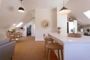 a kitchen and living room with a counter and chairs at Rozendal Stay in Stellenbosch