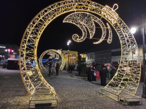 a large metal arch decorated with lights at night at Arcade Apartament in Orăştie