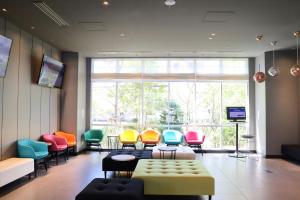 a waiting room with colorful chairs and a large window at ibis Styles Tokyo Bay in Urayasu