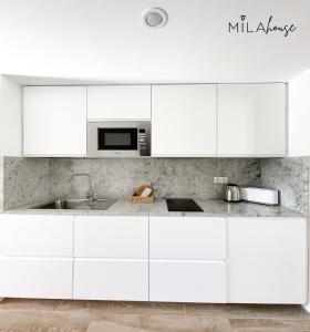 - une cuisine blanche avec évier et four micro-ondes dans l'établissement Amazing Oasi casa Mila wifi free by Rentalfue, à Corralejo