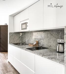 - une cuisine blanche avec évier et four micro-ondes dans l'établissement Amazing Oasi casa Mila wifi free by Rentalfue, à Corralejo