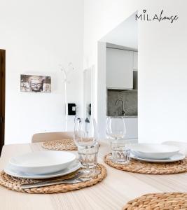 - une table à manger avec des assiettes blanches et des verres à vin dans l'établissement Amazing Oasi casa Mila wifi free by Rentalfue, à Corralejo