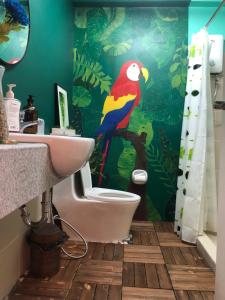 a bathroom with a toilet and a bird on the wall at Staycations by SMS in Manila