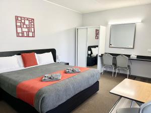Habitación de hotel con cama y escritorio en Gilgandra Motel en Gilgandra