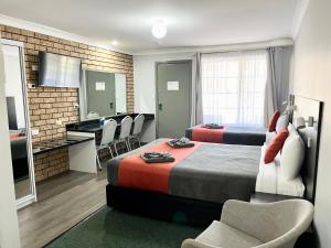 um quarto de hotel com duas camas e uma cozinha em Gilgandra Motel em Gilgandra