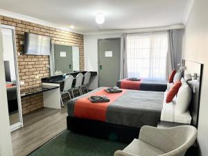 ギルガンドラにあるGilgandra Motelのベッド2台とキッチン付きのホテルの部屋
