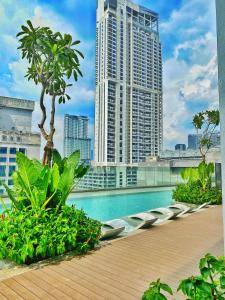 uma piscina no telhado de um edifício com edifícios altos em Oneiro Quill Residence Klcc em Kuala Lumpur