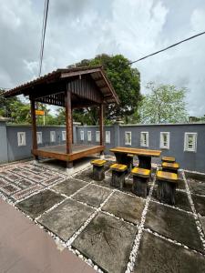 a pavilion with benches and a picnic table at Embun Selasih Homestay in Pasir Gudang