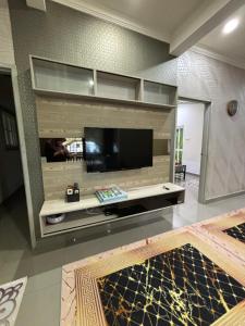 a large living room with a large flat screen tv at Embun Selasih Homestay in Pasir Gudang