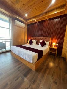 um quarto com uma cama grande e uma parede de madeira em The Walnaut Kasauli em Kasauli