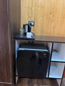 escritorio con cafetera y caja debajo en The Walnaut Kasauli, en Kasauli